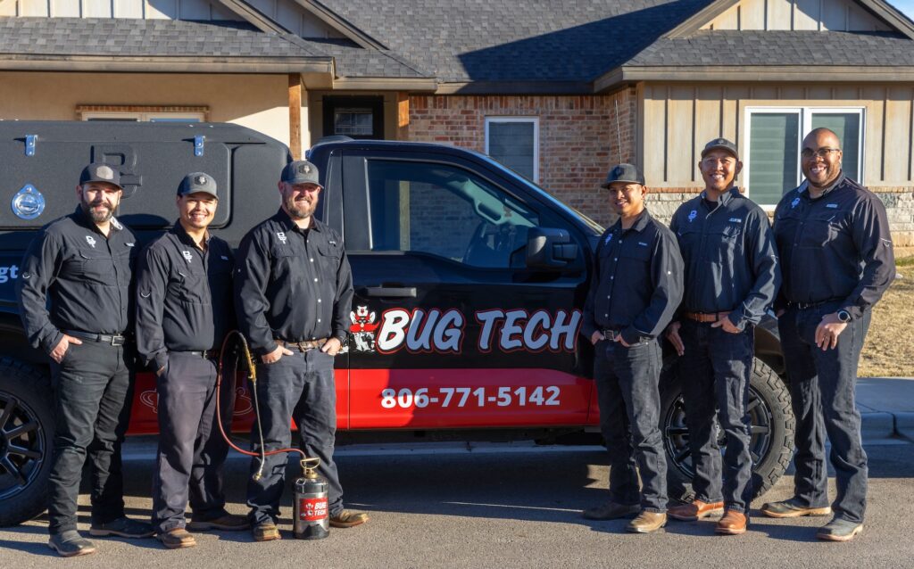 bug tech technicians in front of a truck